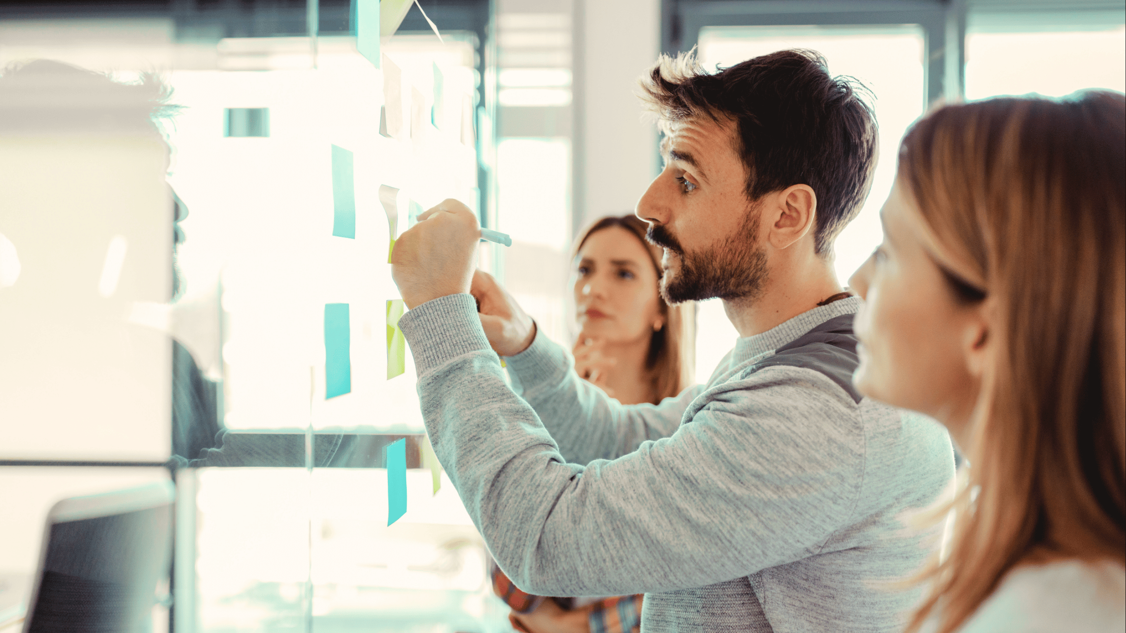 A team brainstorming ideas and writing them on the board | Blog title: Regulated vs Unregulated Power Supplies (Ideal Power)