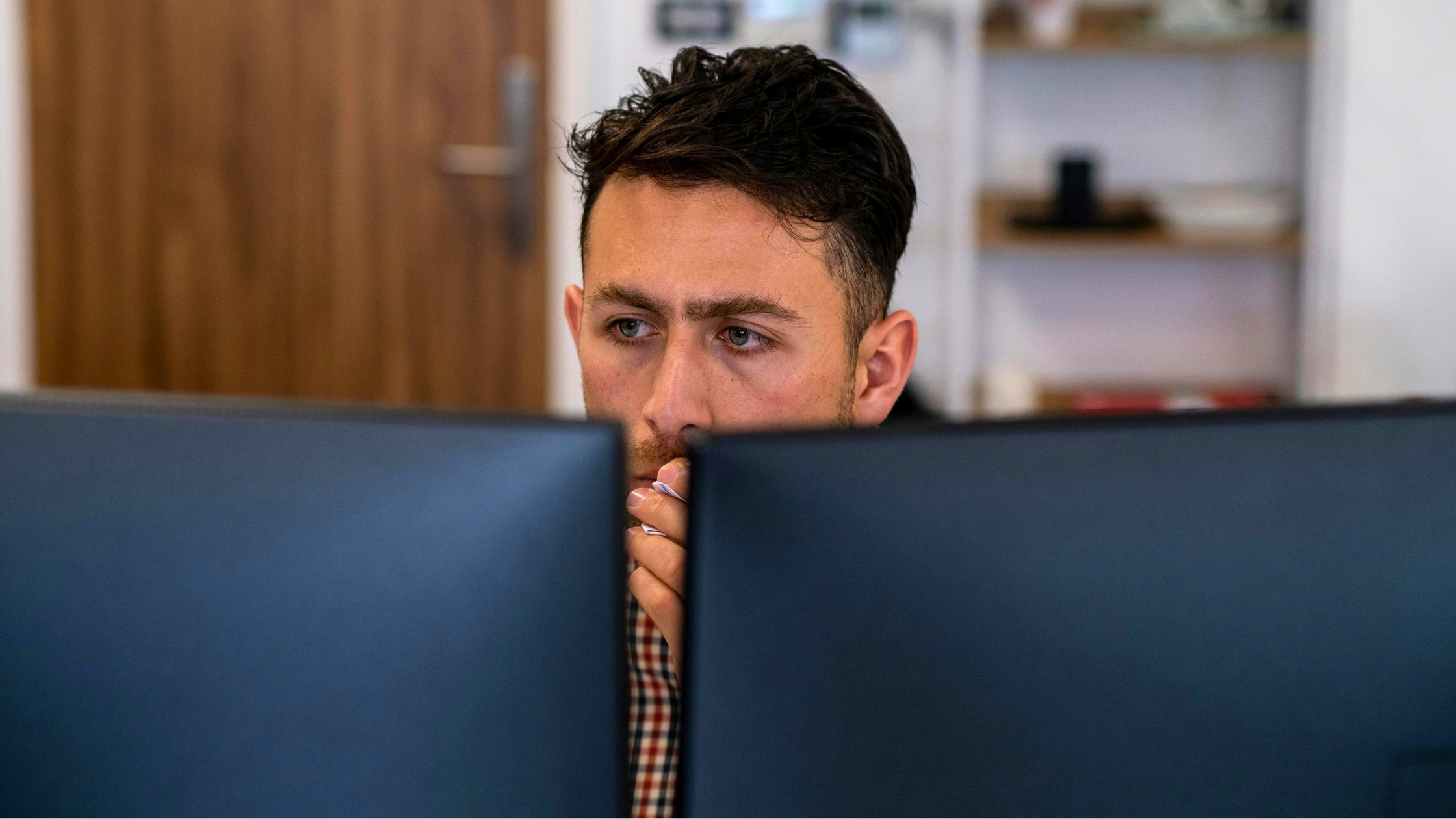 Man looking at computer screens.